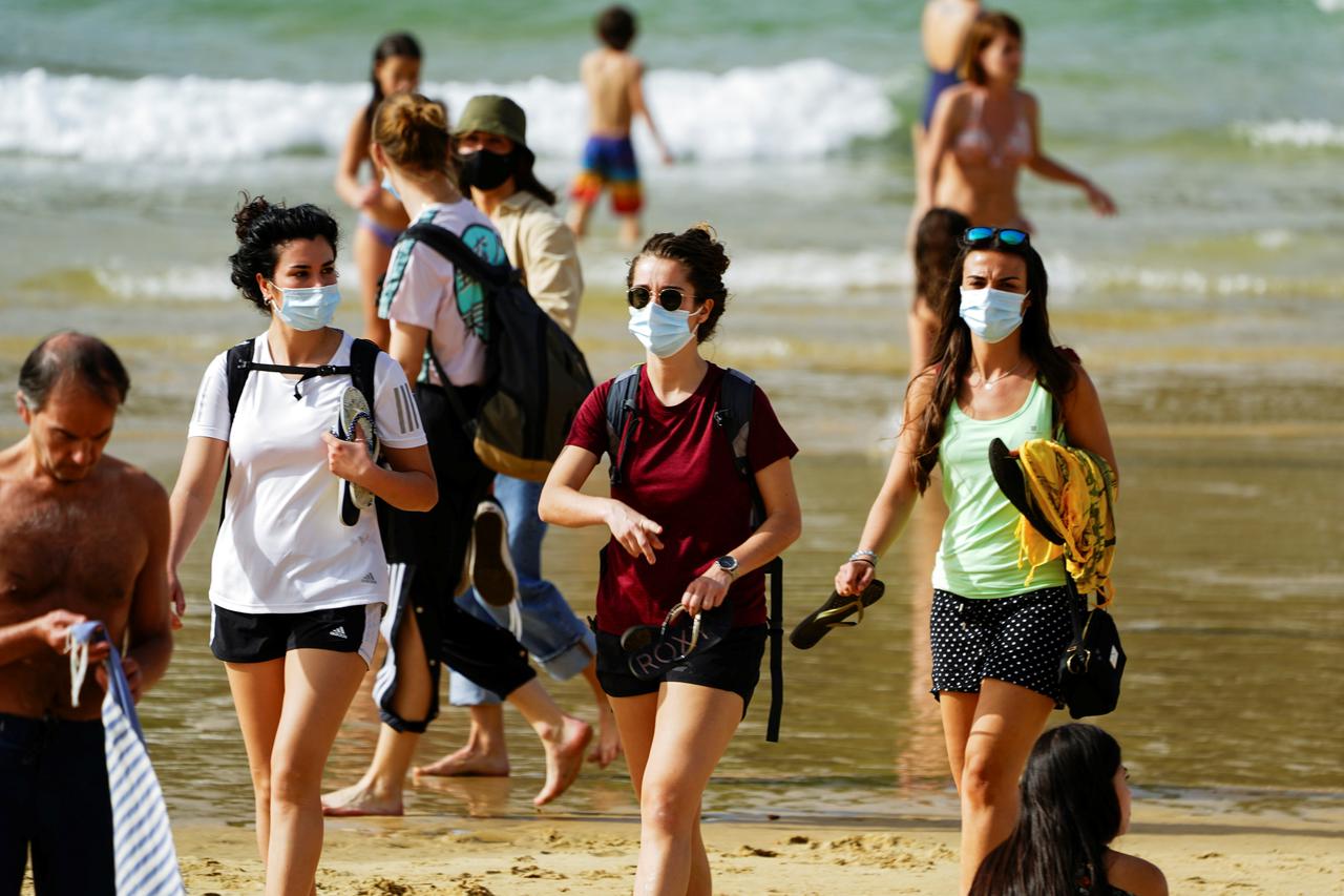 People wear masks at La Concha beach after Spain introduced stricter mask laws during the coronavirus disease (COVID-19) outbreak, in San Sebastian