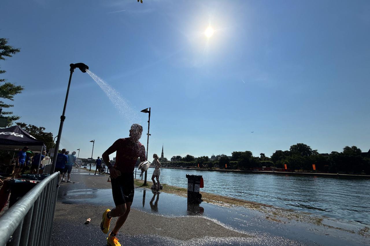 An Ironman athlete runs past a shower near the Main River