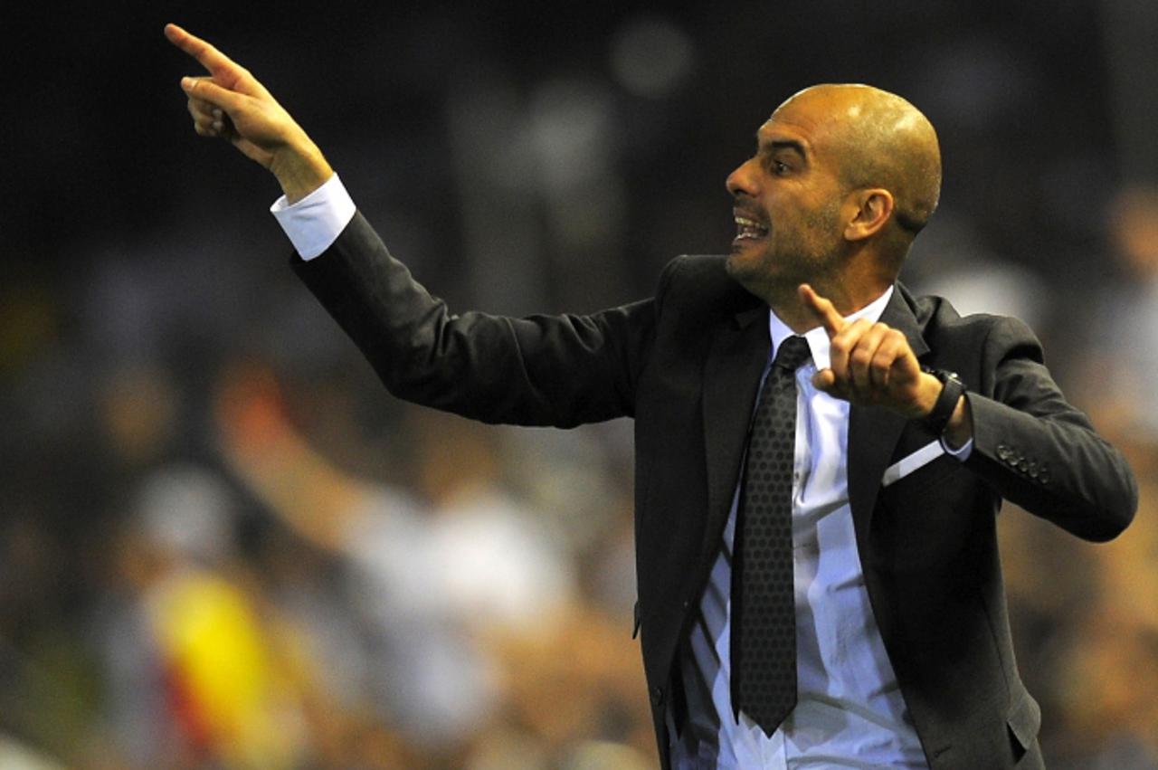 'Barcelona\'s coach Pep Guardiola reacts during the Spanish Cup final match Real Madrid against Barcelona at the Mestalla stadium in Valencia on April 20, 2011. AFP PHOTO/LLUIS GENE'