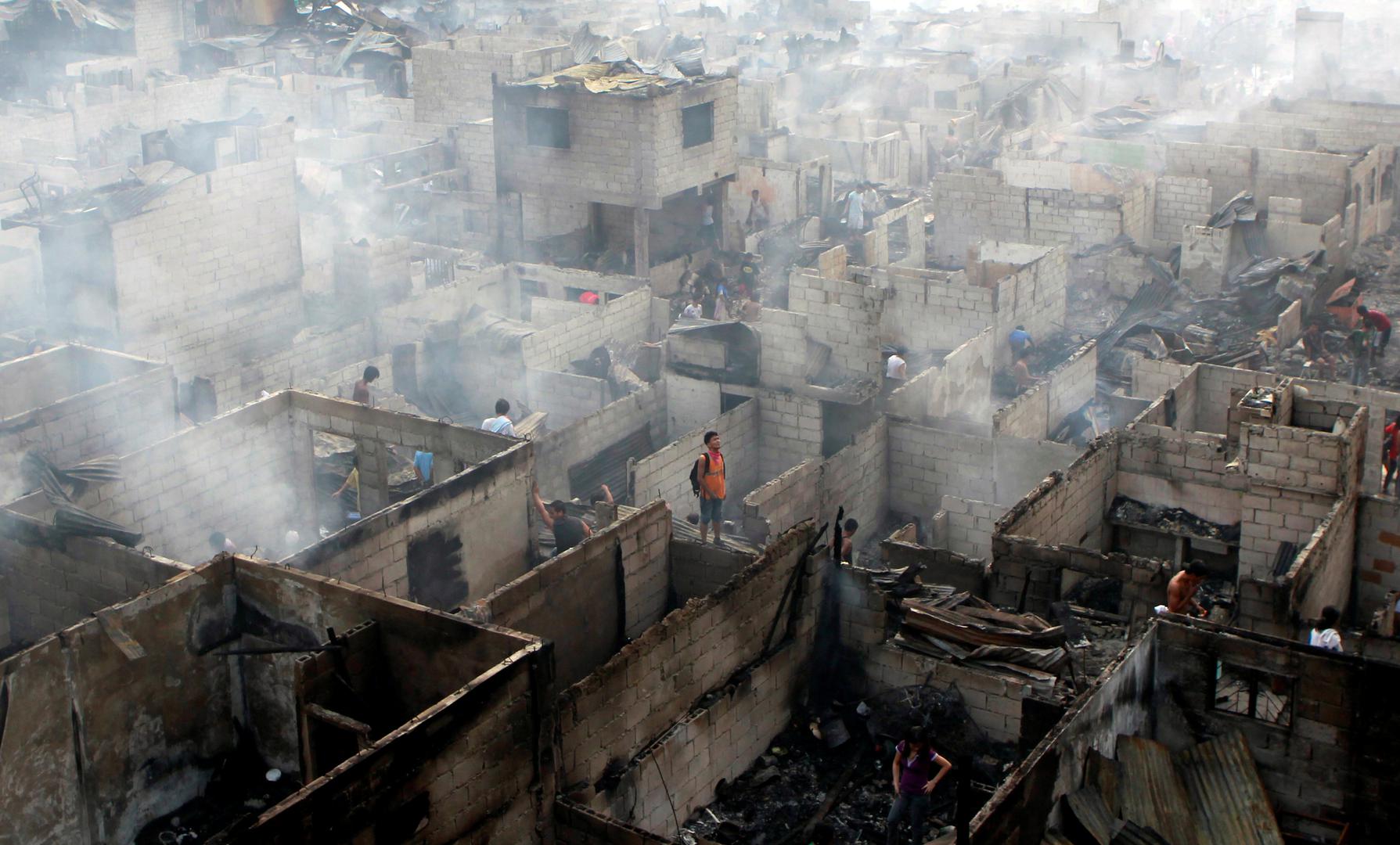 Stanovnici obilaze ruševine svojih kuća nakon požara u filipinskom gradu Makati koji se dogodio 19. travnja 2011.