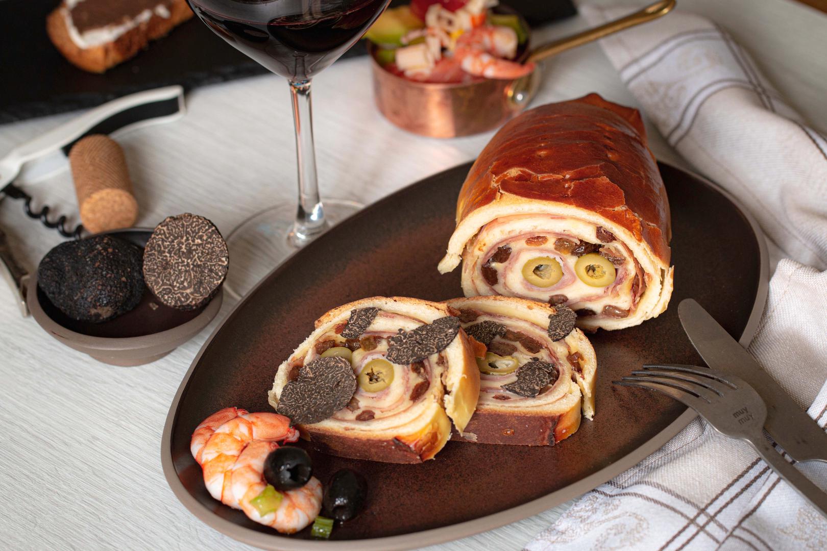 7. Pan de jamón (Venezuela): Venezuelski pan de jamón, slatko-slani kruh "rođen" u pekari u Caracasu 1905. godine, tradicionalno se poslužuje na Badnjak, iako je često dostupan u pekarama tijekom prosinca. Ovaj dugi kruh punjen je pečenom šunkom, grožđicama i zelenim maslinama, a često se poslužuje uz jela poput hallacasa (kuhano kukuruzno tijesto punjeno mesom) i dulce de lechoza (slatki desert od papaje). Za dodatni užitak dodaje se i sir.