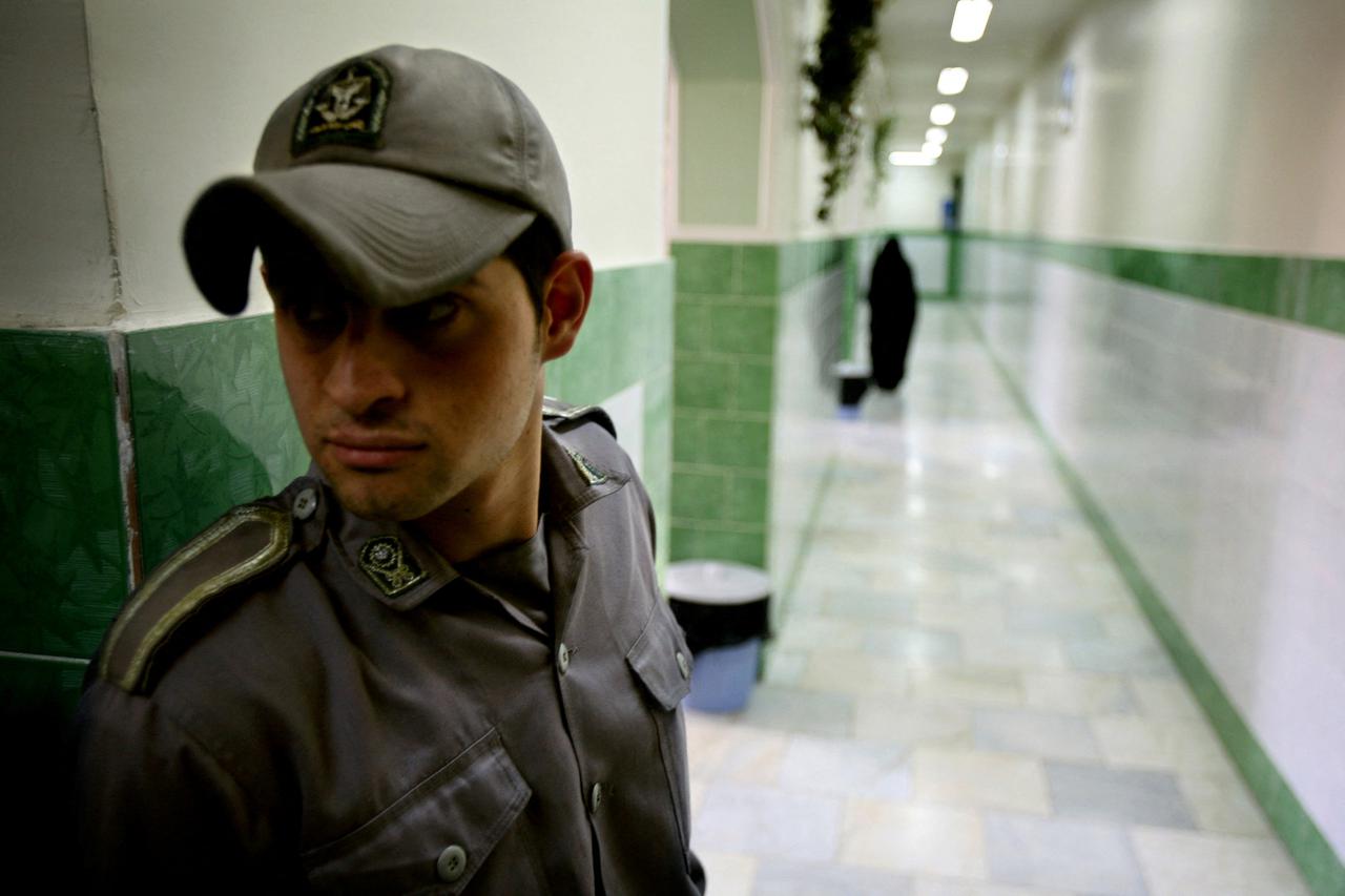 FILE PHOTO: A prison guard stands along a corridor in Tehran's Evin prison June 13, 2006. Iranian police detaine..