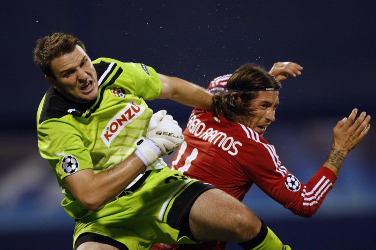 \'Sergio Ramos (R) of Real Madrid fights for a ball with goalkeeper Ivan Kelava of Dinamo Zagreb during their Champions League Group D soccer match at the Maksimir stadium in Zagreb September 14, 2011