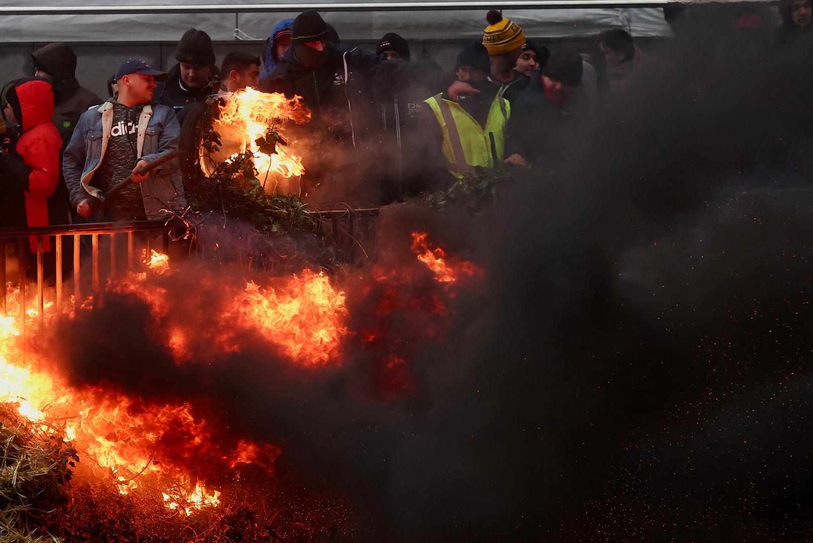 Smoke rises as people take part in a protest of European farmers over price pressures, taxes and green regulation, on the day of an EU Agriculture Ministers meeting in Brussels, Belgium February 26, 2024. REUTERS/Yves Herman Photo: YVES HERMAN/REUTERS