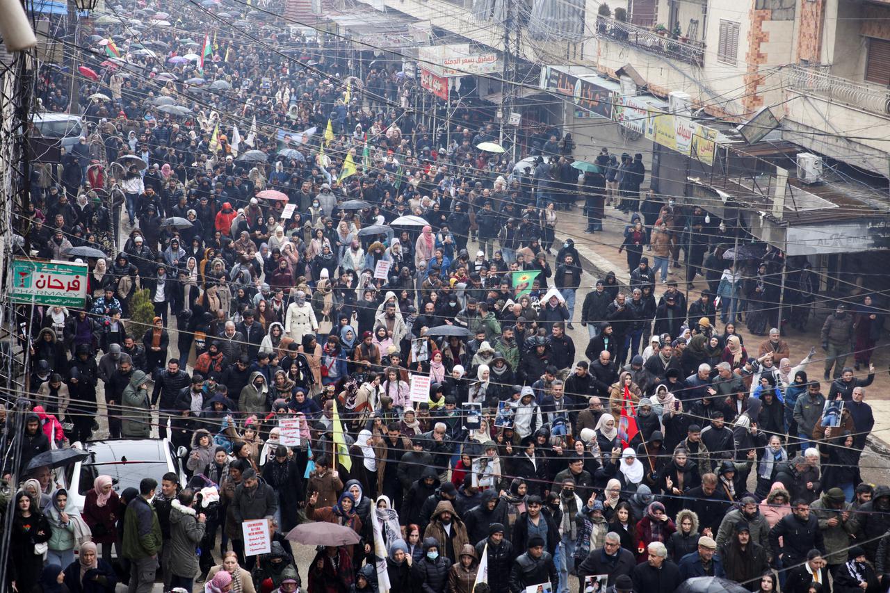 Syrian Kurds attend a protest in solidarity with the people in the neighborhood of Sheikh Maksoud and Ashrafiya, in Qamishli