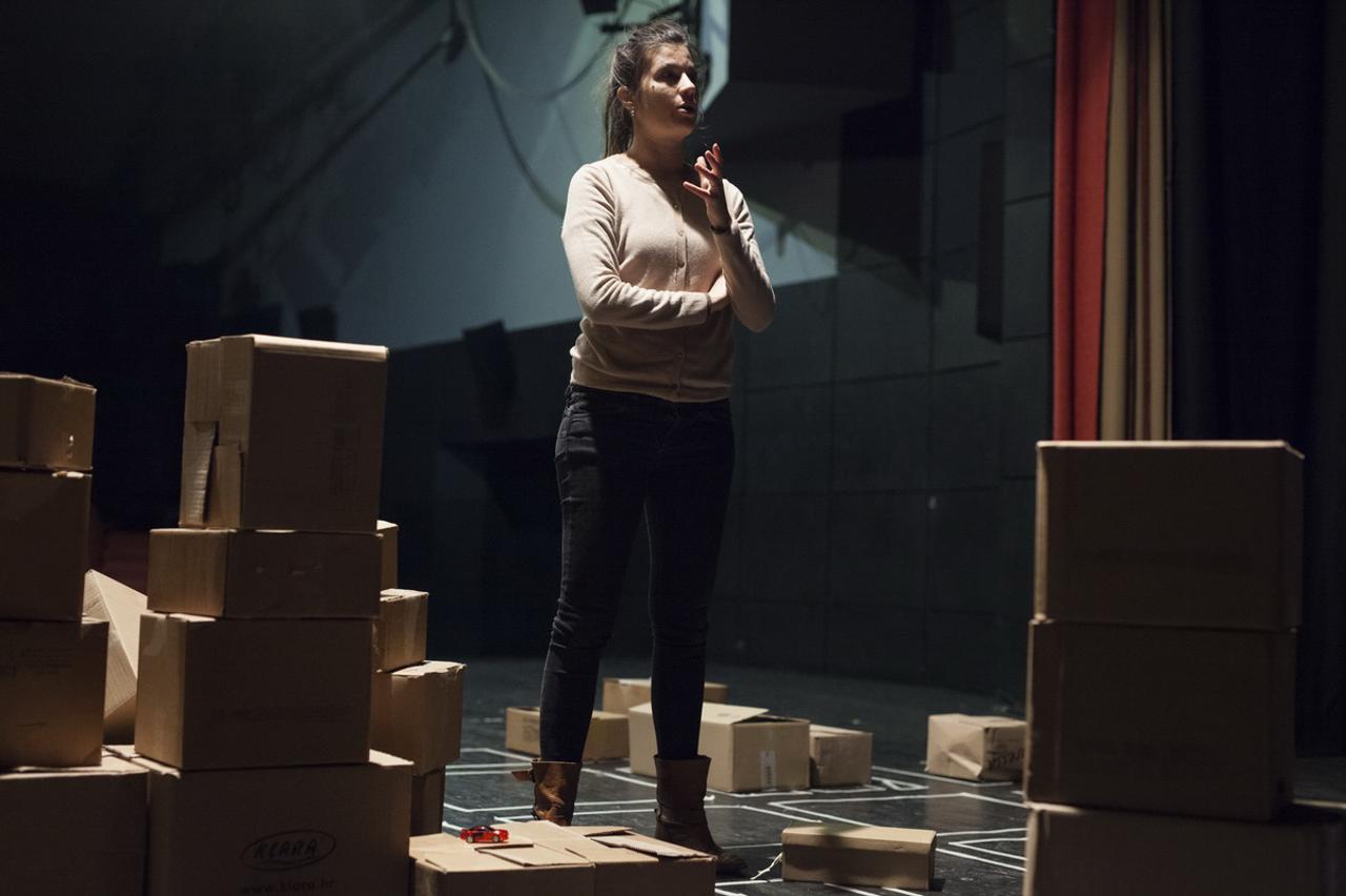 Karla Bibić u sceni predstave u kojoj scenografiju čine – kartonske kutije 