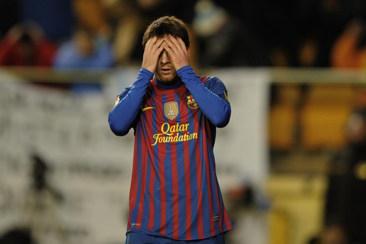 'Barcelona\'s Argentinian forward Lionel Messi (R) reacts during the Spanish league football match Villareal CF vs Barcelona on January 28, 2012 at El Madrigal stadium in Villareal. The match ended in