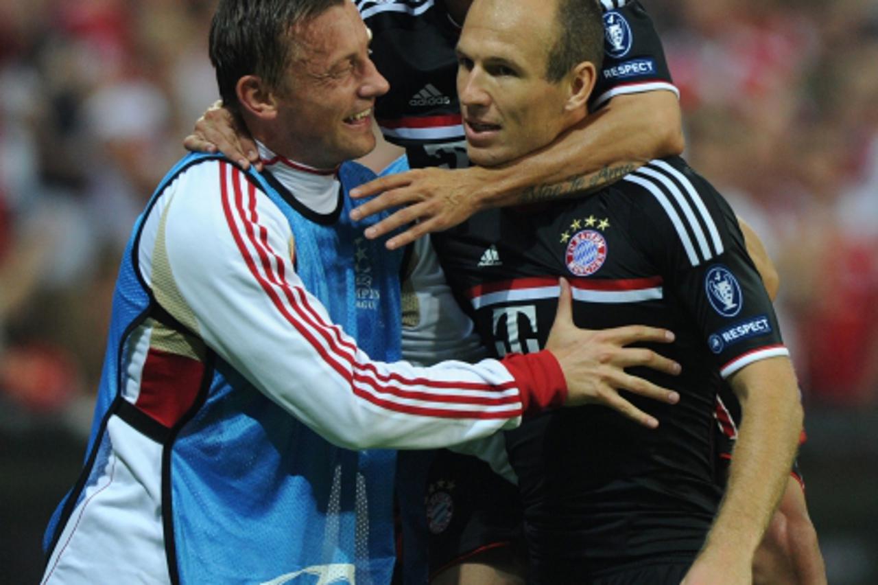 'Bayern Munich\'s dutch midfielder Arjen Robben (R) celebrates scoring with his teammates Croatian striker Ivica Olic (L) and Brazilian defender Rafinha during the UEFA Champions League play off match
