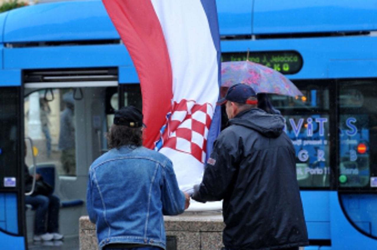 \'03.11.2009.,Zagreb - Trg bana Josipa Jelacica - kisni dan, pada kisa, ljudi, kisobrani, skidanje hrvatske zastave radi pocetka kicenja grada zbog blagdana Photo: Marko Lukunic/PIXSELL\'