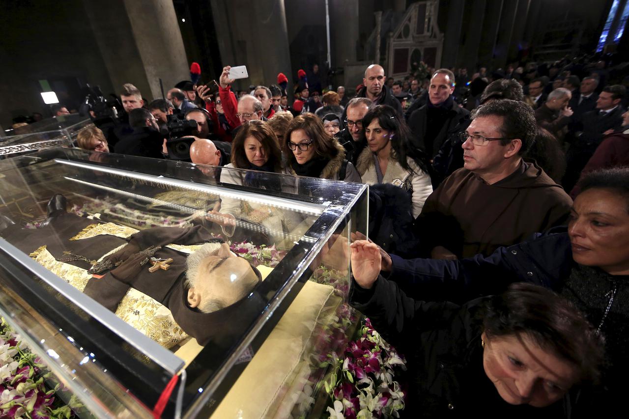 Faithful surround the exhumed body of the mystic saint Padre Pio in the Catholic church of San Lorenzo fuori le Mura in Rome, February 3, 2016. The body of one of the most popular Roman Catholic saints, the mystic monk Padre Pio began an overland journey 
