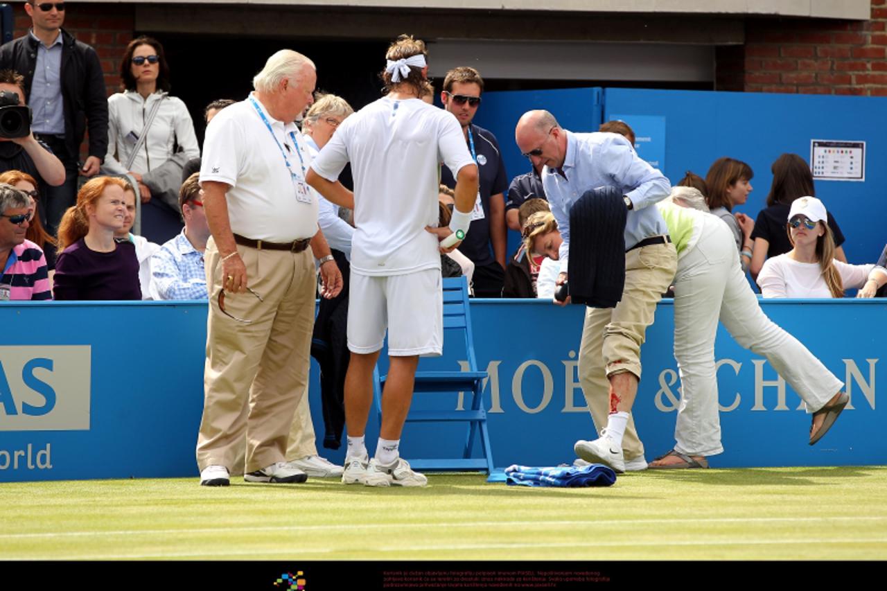 'Argentina\'s David Nalbandian (centre) loses the match by default after an incident involving a line judge (centre right) needing medical treatment for a cut to the leg during the final on day seven 