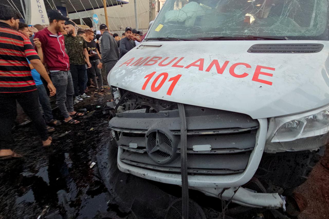 Palestinians check the damage of an ambulance convoy