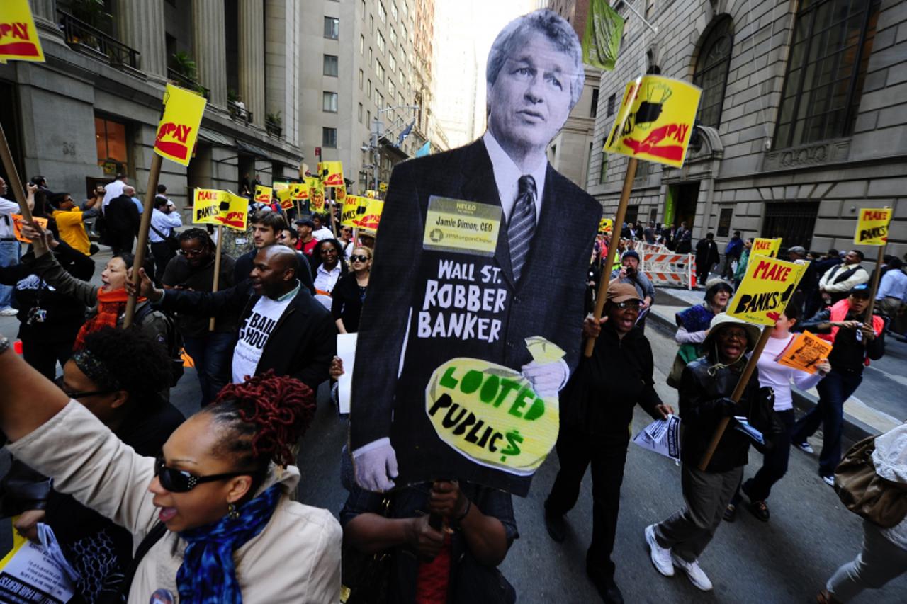 'Labor-Community Coalition activists march down Wall Street holding a cutout of JP Morgan CEO Jamie Dimon, during a protest against budget cuts and bank practices, in New York, May 12, 2011.Thousands 
