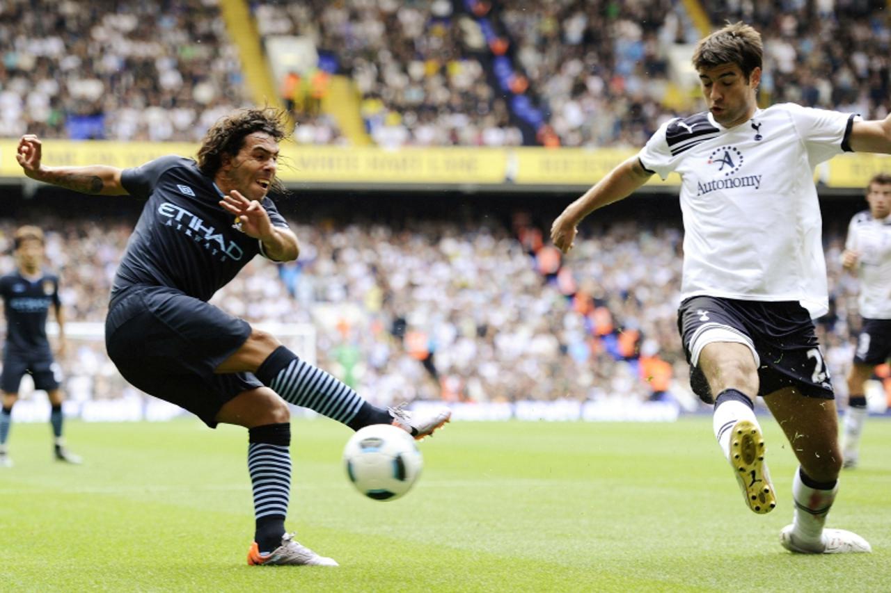 'Tottenham Hotspur\'s Vedran Corluka (R) blocks a shot on goal by Manchester City\'s Carlos Tevez during their English Premier League soccer match at White Hart Lane in London August 14, 2010. REUTERS