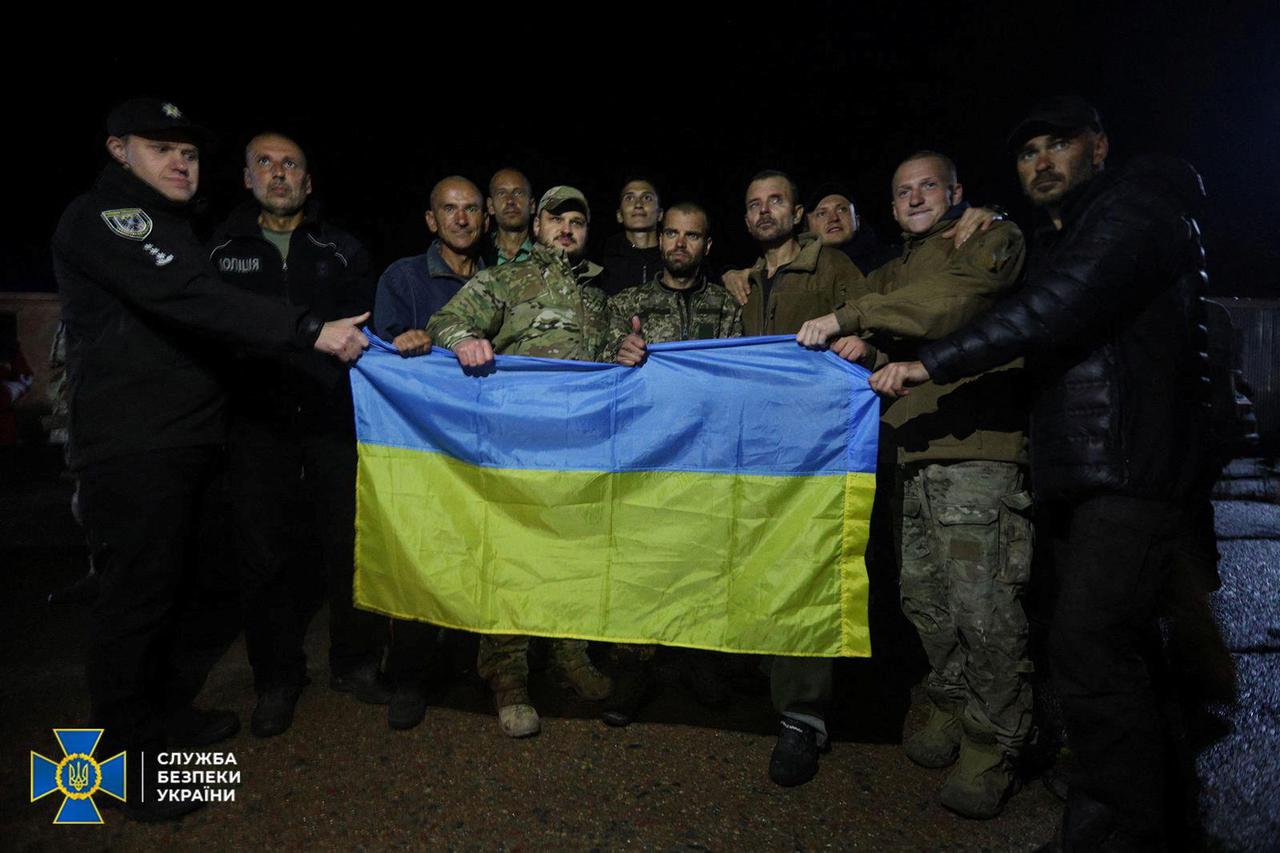 Ukrainian prisoners of war (POWs) pose for a picture with a national flag after a swapping in Chernihiv region