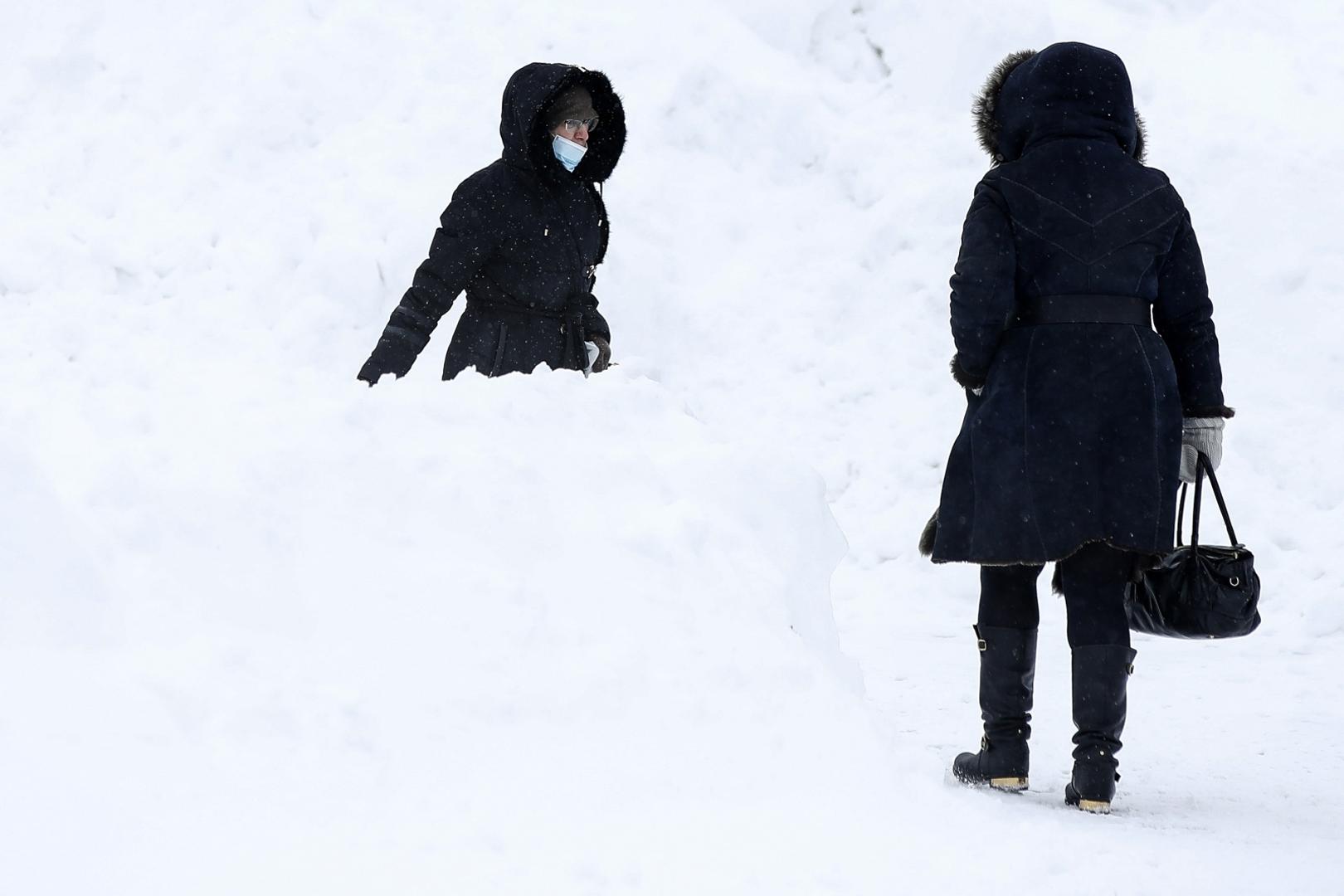 MOSCOW, RUSSIA - FEBRUARY 13, 2021: Women walk among banks of snow outside the VDNKh Exhibition Centre. Artyom Geodakyan/TASS Photo via Newscom Newscom/PIXSELL