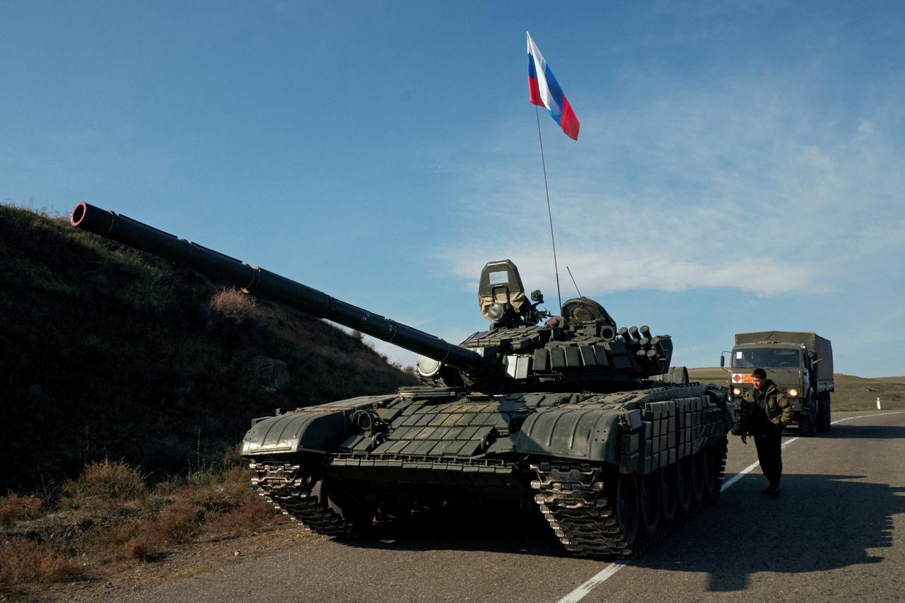 FILE PHOTO: A service member of the Russian peacekeeping troops stands next to a tank in Nagorno-Karabakh