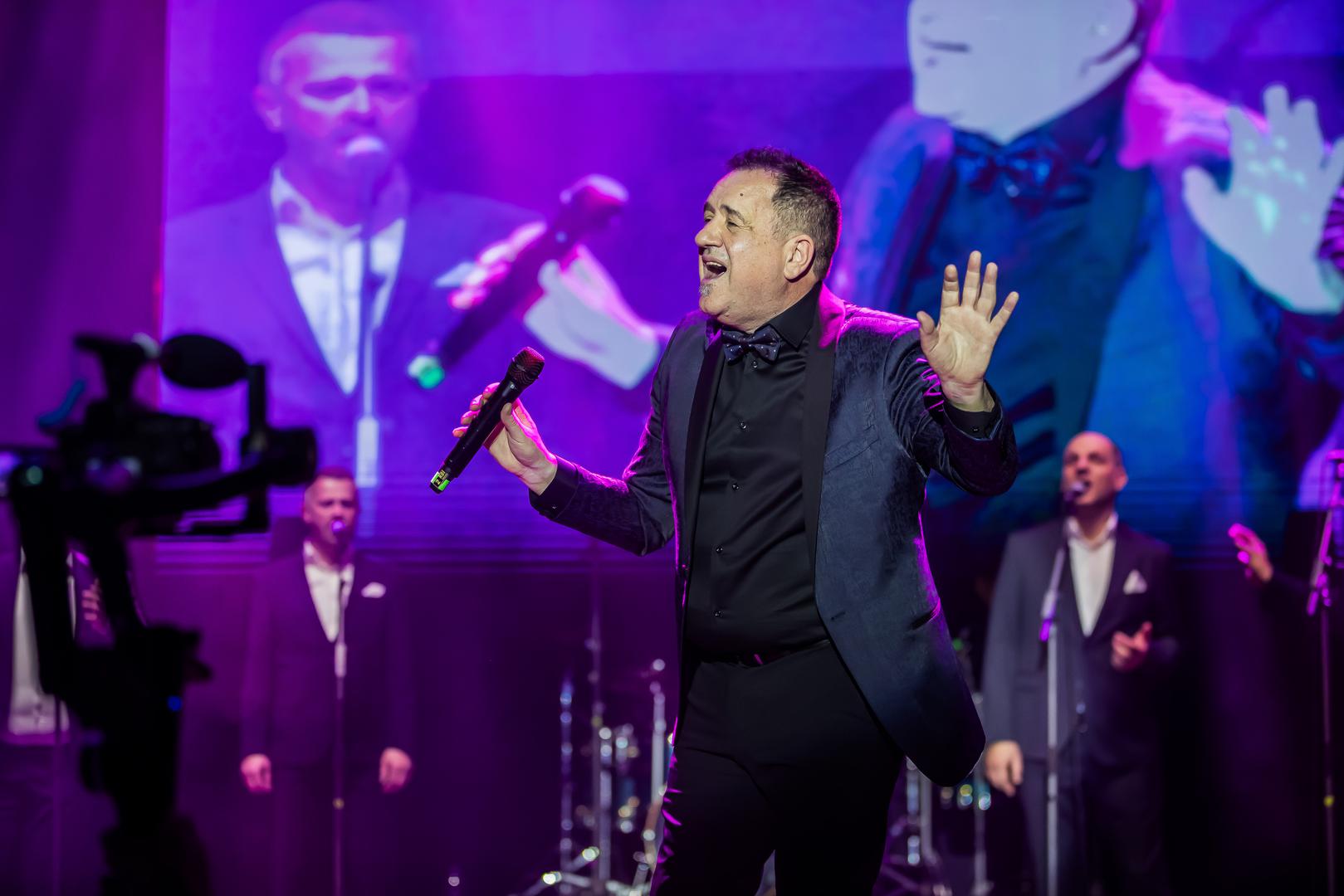 Publika je velikim aplauzom pozdravila najvećeg domaćeg kantautora Nenu Belana koji je nasmijao sve rekavši kako je lijepo biti među dječacima:
„Ja i Kozomara smo 45 godina zajedno, mi smo prijatelji prije svih karijera, nismo znali di će nas život odnit. On je živio di i moj kum i sva trojica smo obožavali klapsko pivanje, di bi se god vidili u portunu ili negdi drugo mi bi krenili klapsko pivanje. Bili smo mladi i ludi za klapama i njemu je to obilježilo cili život, ali i meni.“ 