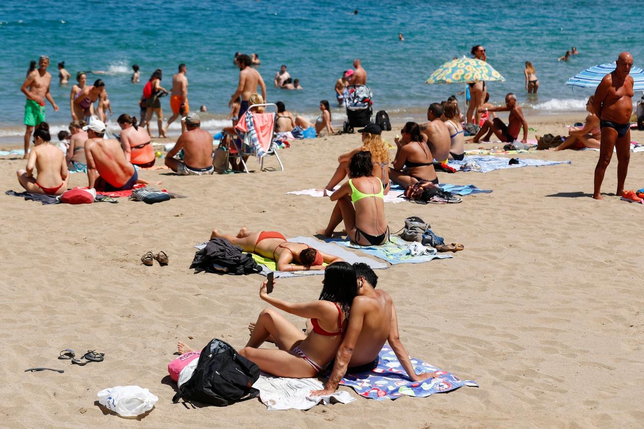 A couple takes a selfie while sunbathing on Las Canteras beach as some Spanish provinces are allowed to ease lockdown restrictions during phase two, amid the coronavirus disease (COVID-19) outbreak, in Las Palmas de Gran Canaria