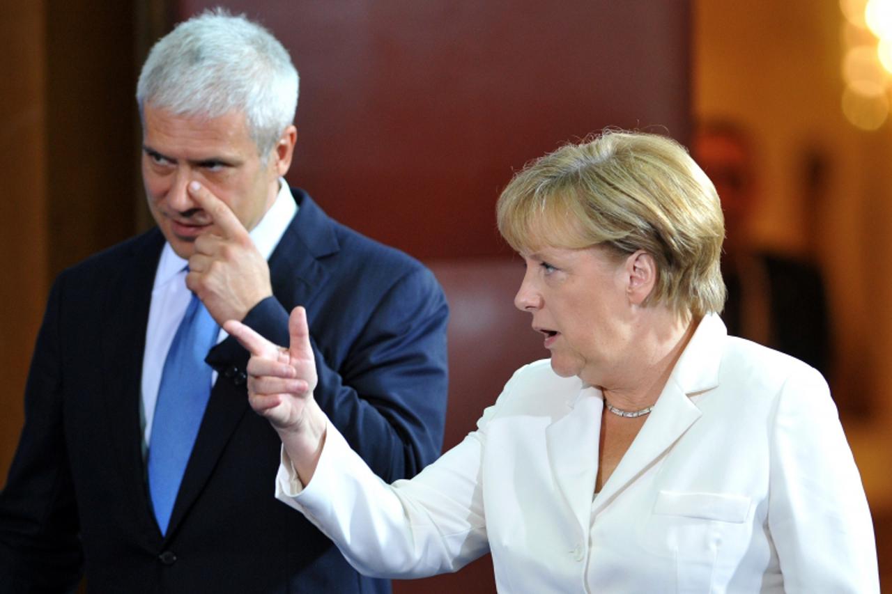 'Serbian President Boris Tadic and German Chancellor Angela Merkel arrive at a joint conference after their meeting on August 23, 2011, in Belgrade.  Merkel visits Serbia several days ahead of the res