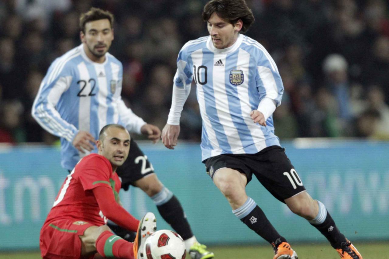 'Argentina\'s Lionel Messi (R) fights for the ball with Portugal\'s Carlos Martins during their international friendly soccer match at the Stade de Geneve in Geneva February 9, 2011. REUTERS/Denis Bal