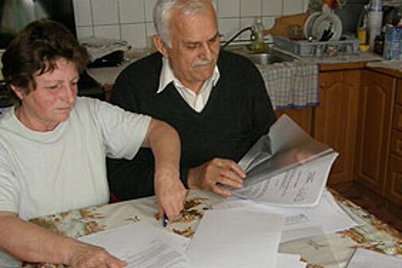  Supružnici Rade pokazuju svoju dokumentaciju o kući 