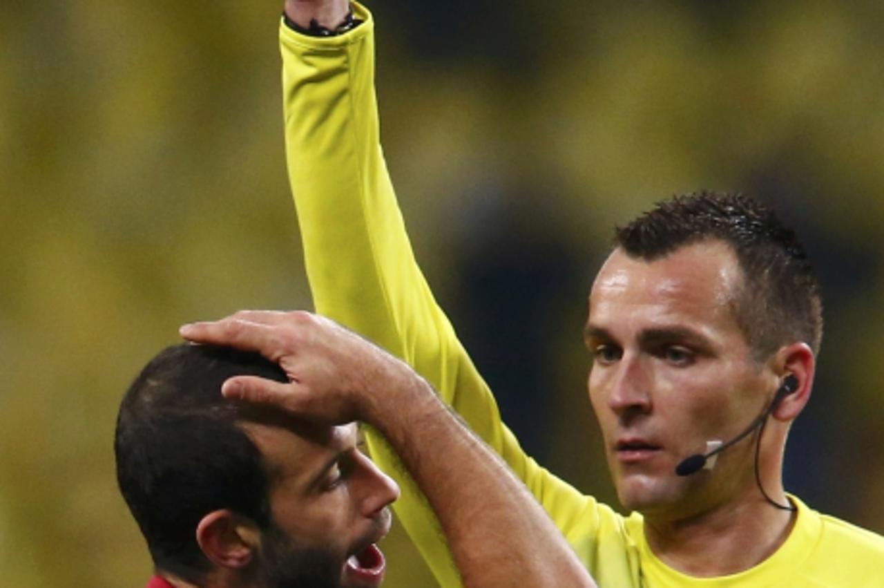 'Barcelona\'s Javier Mascherano (L) is shown a yellow card by match referee Ivan Bebek during their Champions League Group G soccer match against Spartak Moscow at Luzhniki stadium in Moscow November 