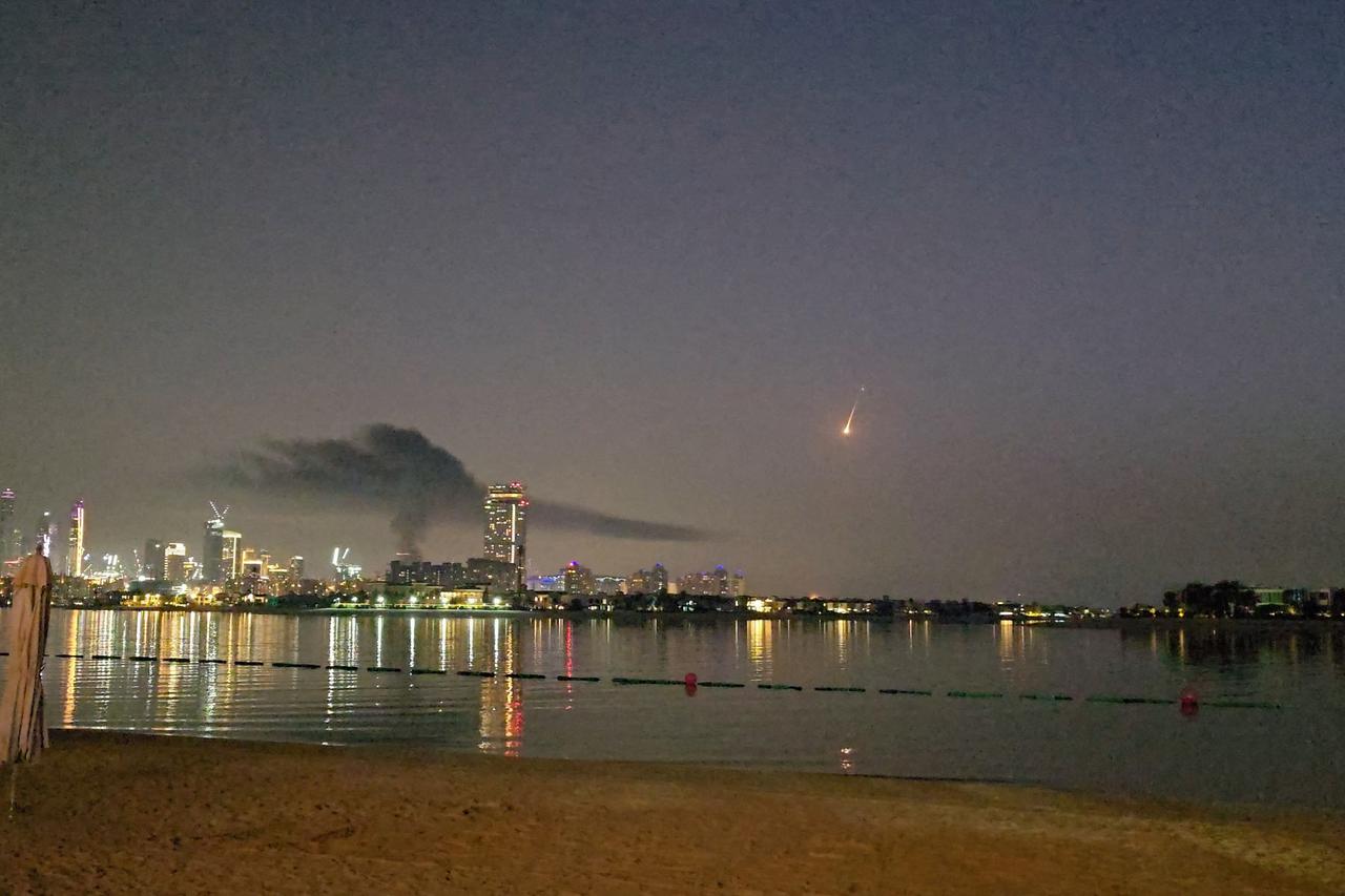 Smoke rises over a hotel damaged in Dubai's famed Palm Jumeirah, in Dubai