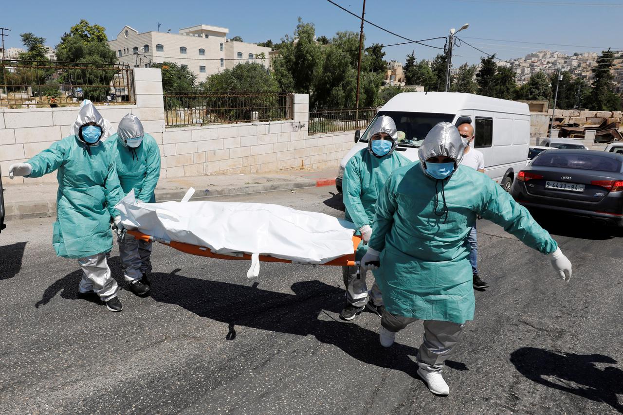 Palestinians bury a woman who has died after contracting COVID-19