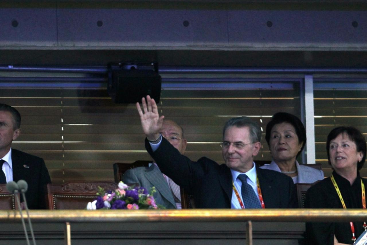 'International Olympic committee chairman Jacques Rogge (R) waves prior to the opening ceremony for the International Association of Athletics Federations (IAAF) World Championships in Daegu on August