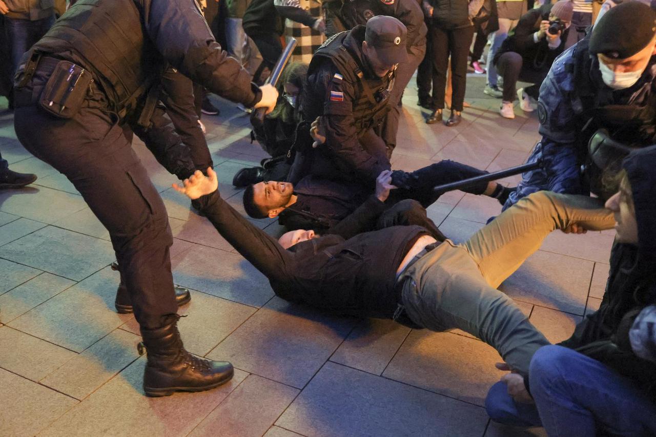 Russian police officers detain men during an unsanctioned rally in Moscow