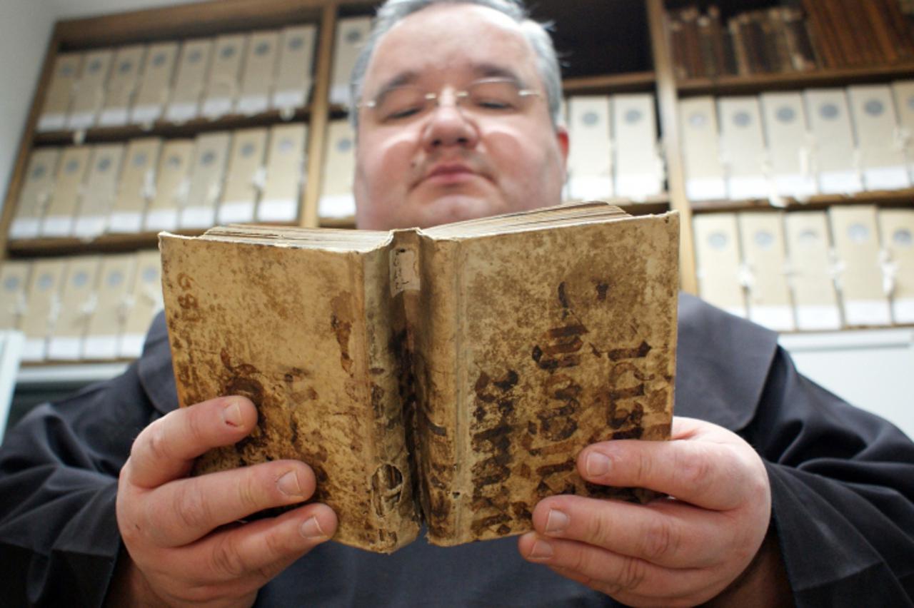 'slavonija, virovitica, 02.06.2011. zupnik zupe sv. roka u virovitici fra robert perisic sa starom knjigom crkvenih obreda cije su korice vec jednom bile koristene - pergamena se nije bacala nego kori