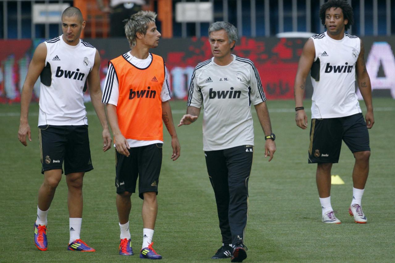 \'Real Madrid\'s coach Jose Mourinho talks to players Karim Benzema (L), Fabio Coentrao (2nd L) and Marcelo (R) during their training ahead of the Supercup meeting with European and domestic champions