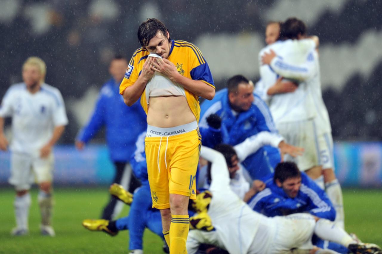 'Ukraine\'s Artem Milevskyi passes by players of Greece as they react after the World Cup 2010 play-off qualification football game in Donetsk on November 18, 2009. Greece won 1:0. AFP PHOTO / SERGEI 