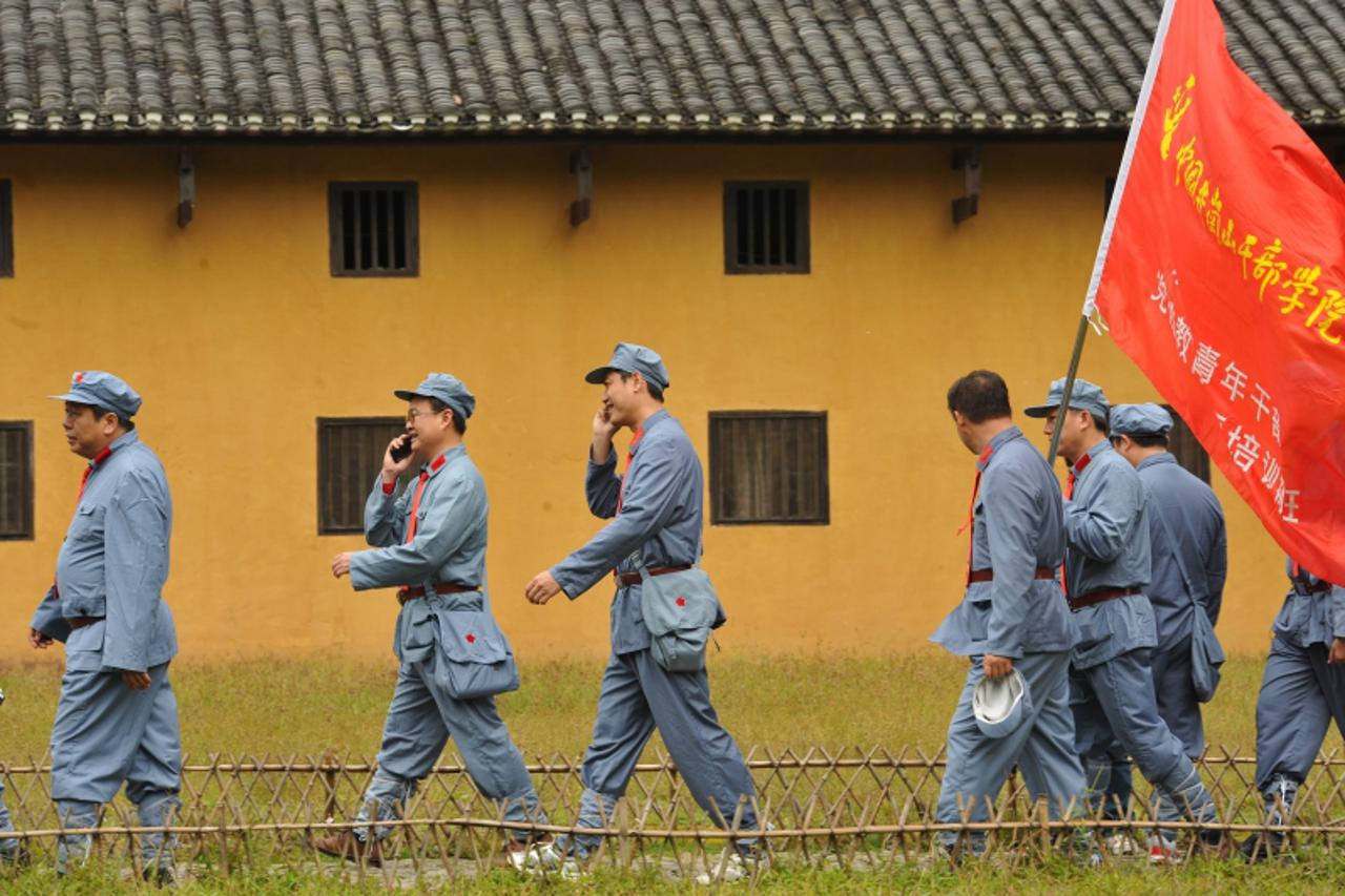 'Photo taken on September 21, 2012 shows visitors dressed in red army uniforms visiting places former Chinese leader Mao Zedong used to stay, during an educational tour in Jinggangshan in central Chin