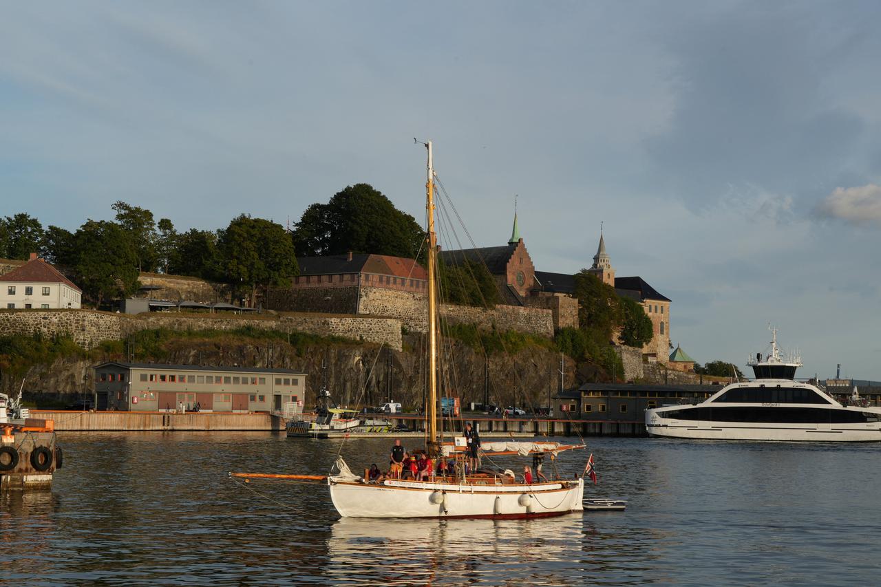 A boat sails past Akershus Fortress in Oslo
