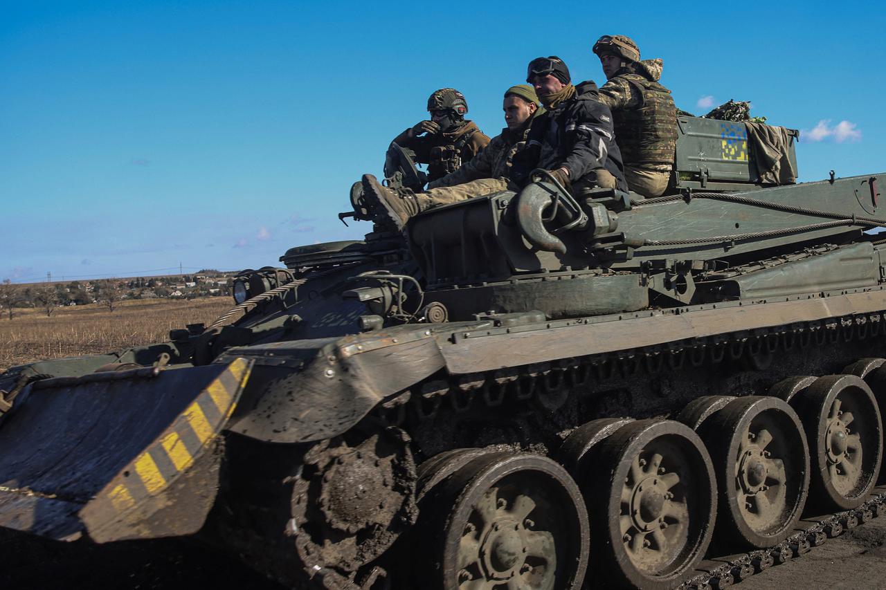 Ukrainian servicemen ride along a road atop of an armoured engineer vehicle in Donetsk region