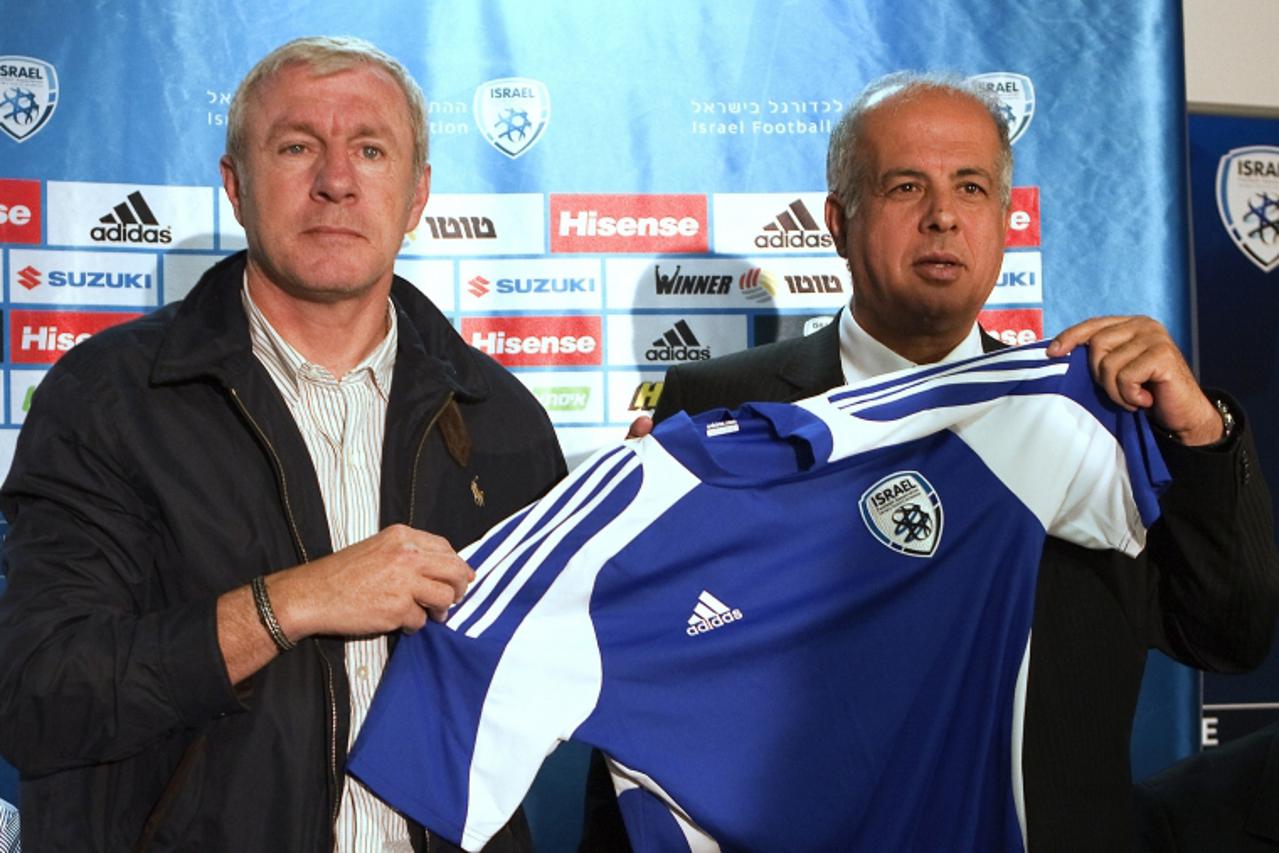 'Avi Luzon (R), chairman of the Israel Football Association, presents the jersey of the Israeli national football team to Luis Fernandez, former head coach of Paris St Germain and Betar Jerusalem, dur