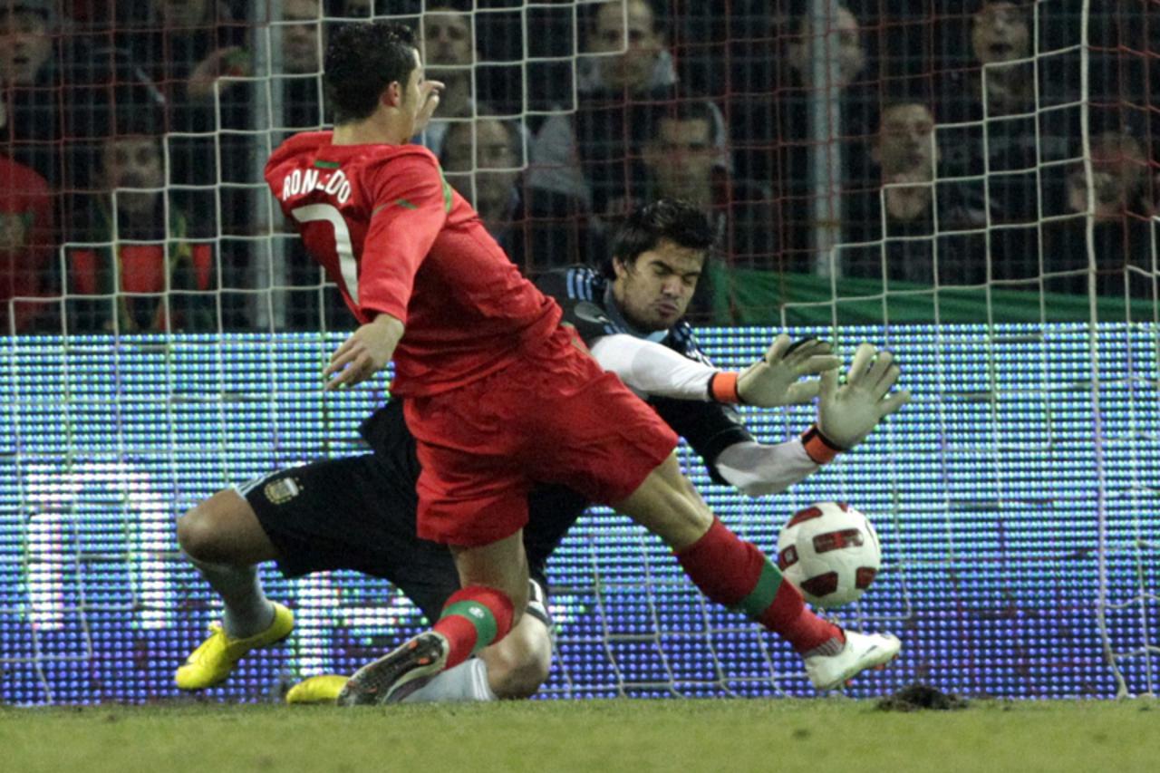 \'Portugal\'s Cristiano Ronaldo (L) scores a goal against Argentina\'s goalkeeper Sergio Romero during their international friendly soccer match at the Stade de Geneve in Geneva February 9, 2011. REUT