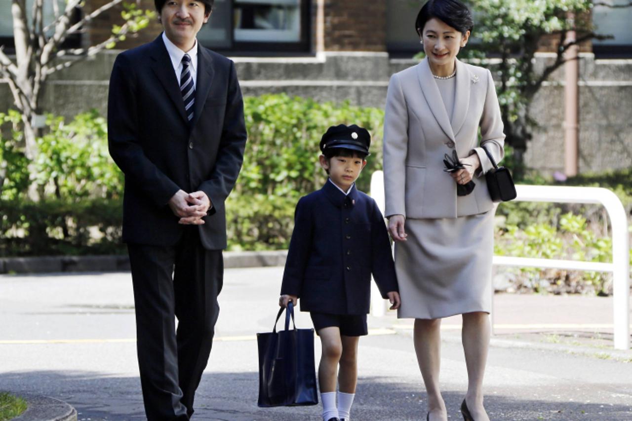 'Japan\'s Prince Hisahito (C) accompanied by his parents Prince Akishino (L) and Princess Kiko, arrive at Ochanomizu University Elementary School for his entrance ceremony in Tokyo April 7, 2013.  REU