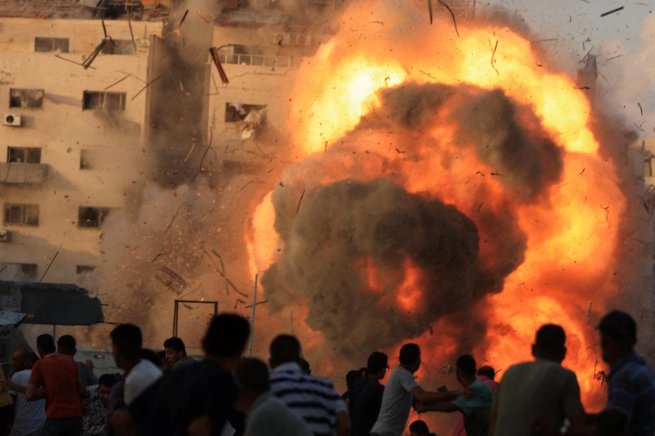 Smoke and flames rise as a residential building collapses after an Israeli air strike, in Gaza City