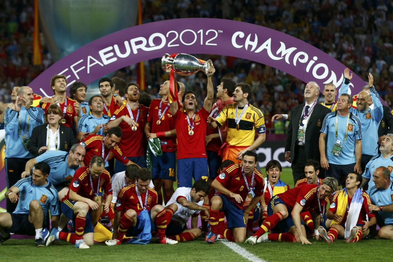 'Spain\'s Alvaro Arbeloa (C) holds up the trophy next to his team mates after defeating Italy to win the Euro 2012 final soccer match at the Olympic stadium in Kiev July 1, 2012.  REUTERS/Eddie Keogh 
