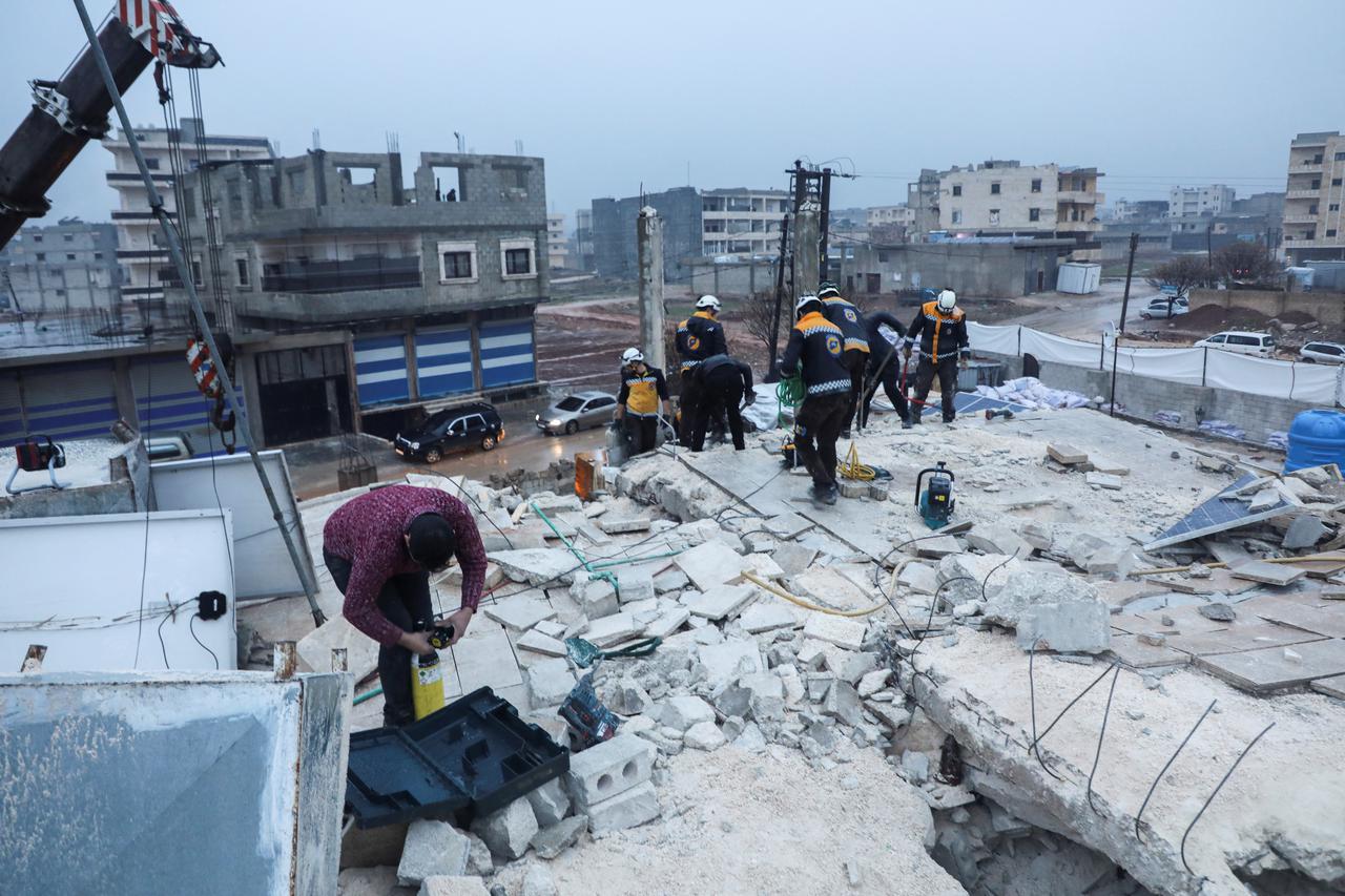 Rescuers work at the site of a damaged building, following an earthquake, in rebel-held Azaz