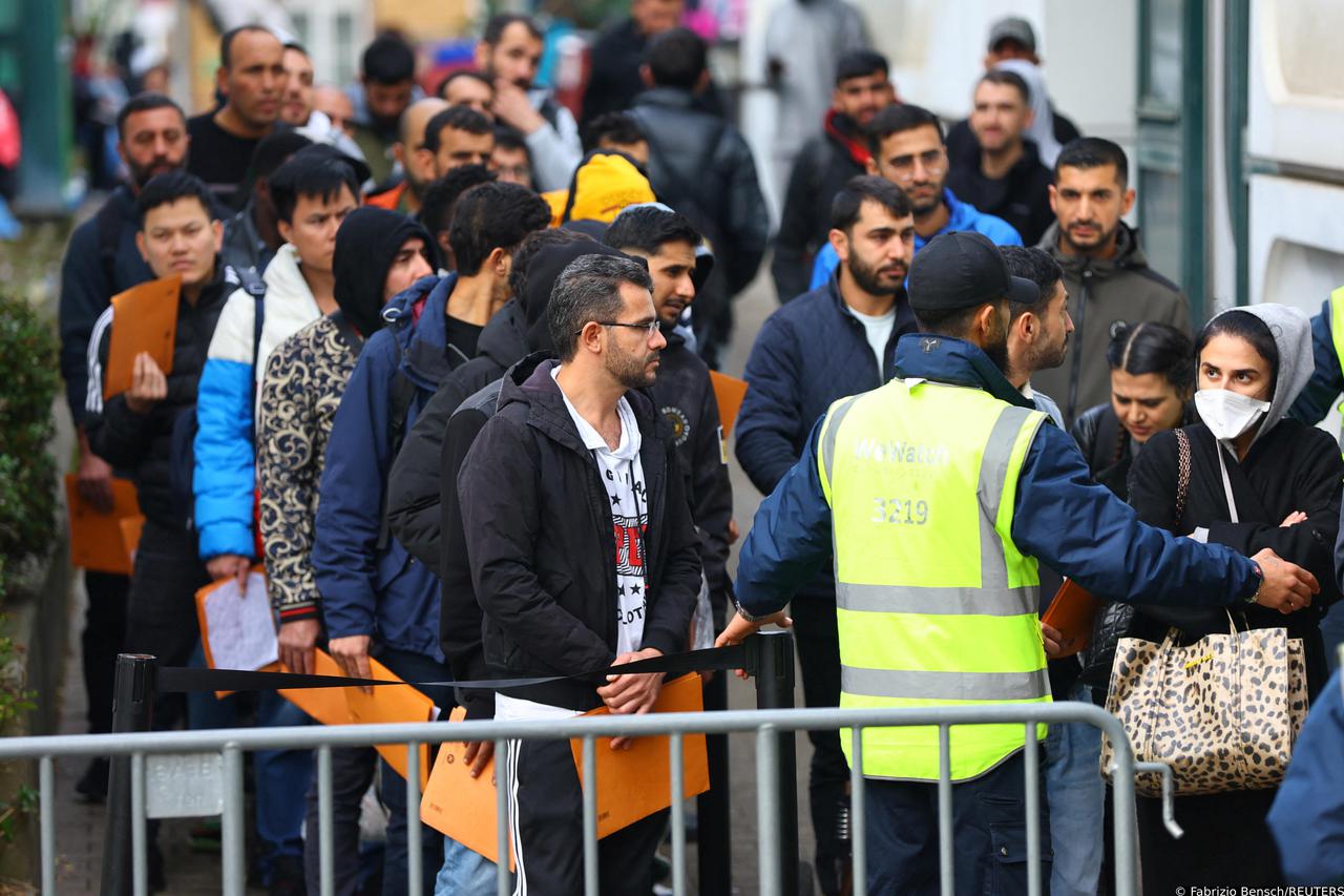 Migrants queue at the arrival centre for asylum seekers at Reinickendorf district in Berlin