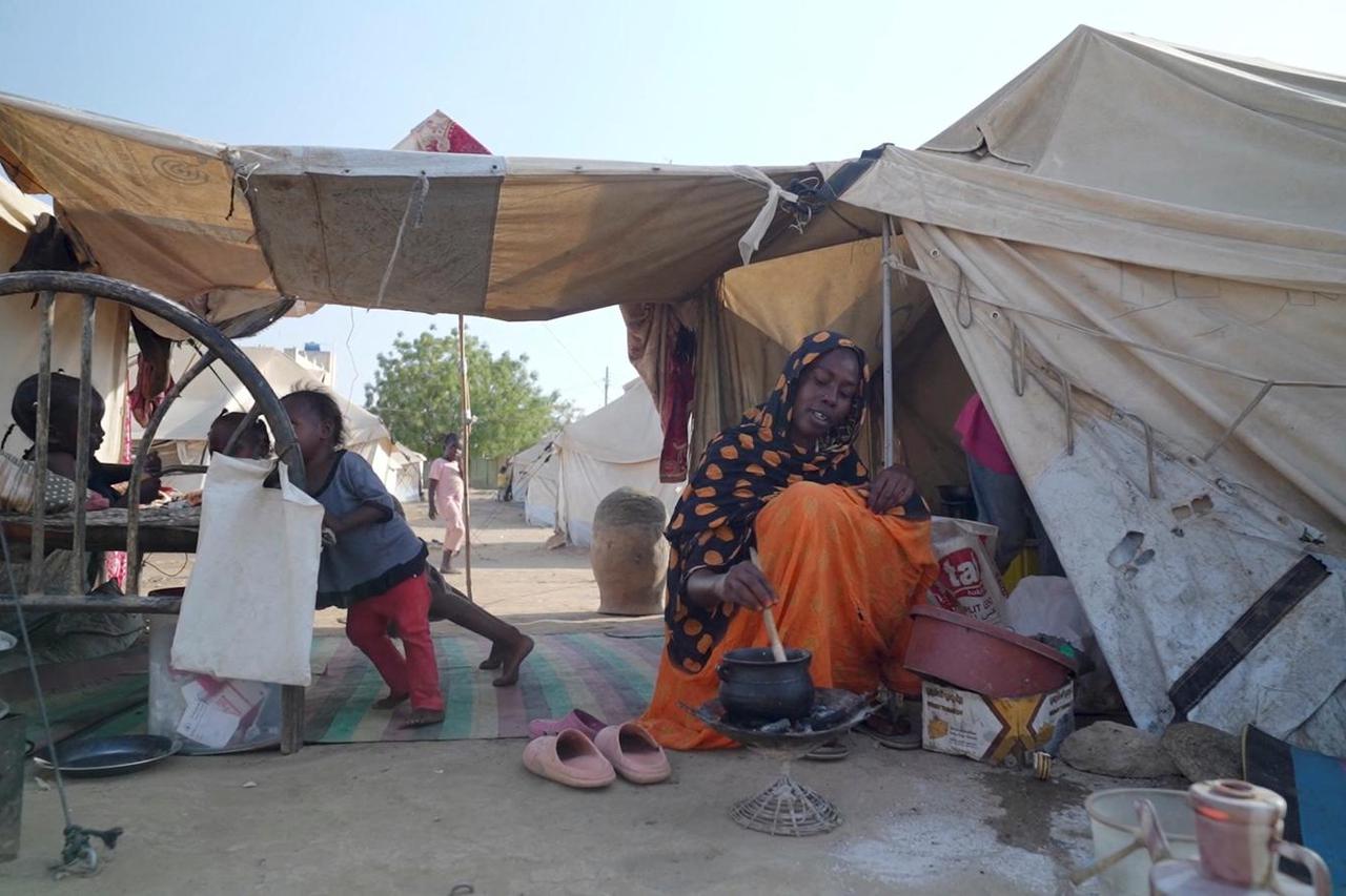 Awadiya Al-Day Ibrahim prepares meal for her family with World Food Programme (WFP) food supplies at a tent, in Kassala