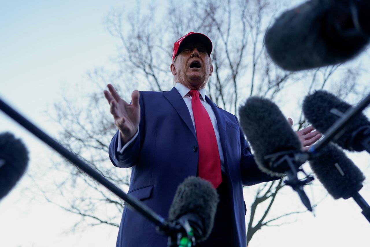 U.S. President Donald Trump speaks with members of the media on the South Lawn before boarding Marine One at the White House