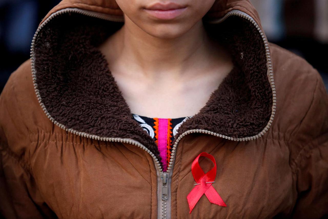 FILE PHOTO: A participant with a red ribbon pin takes part in HIV/AIDS awareness campaign ahead of World Aids Day, in Kathmandu