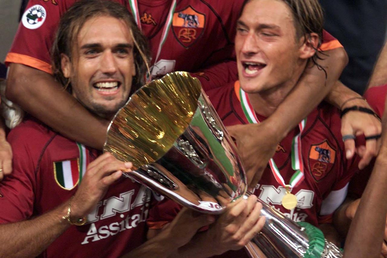 AS Roma's Francesco Totti (R) celebrates with the trophy together with Gabriel Batistuta (L), Marcos Cafu (up) and Jonathan Zebina at the end of the Italian Supercup match against Fiorentina at Olympic Stadium in Rome August 19, 2001. Roma won the match 3