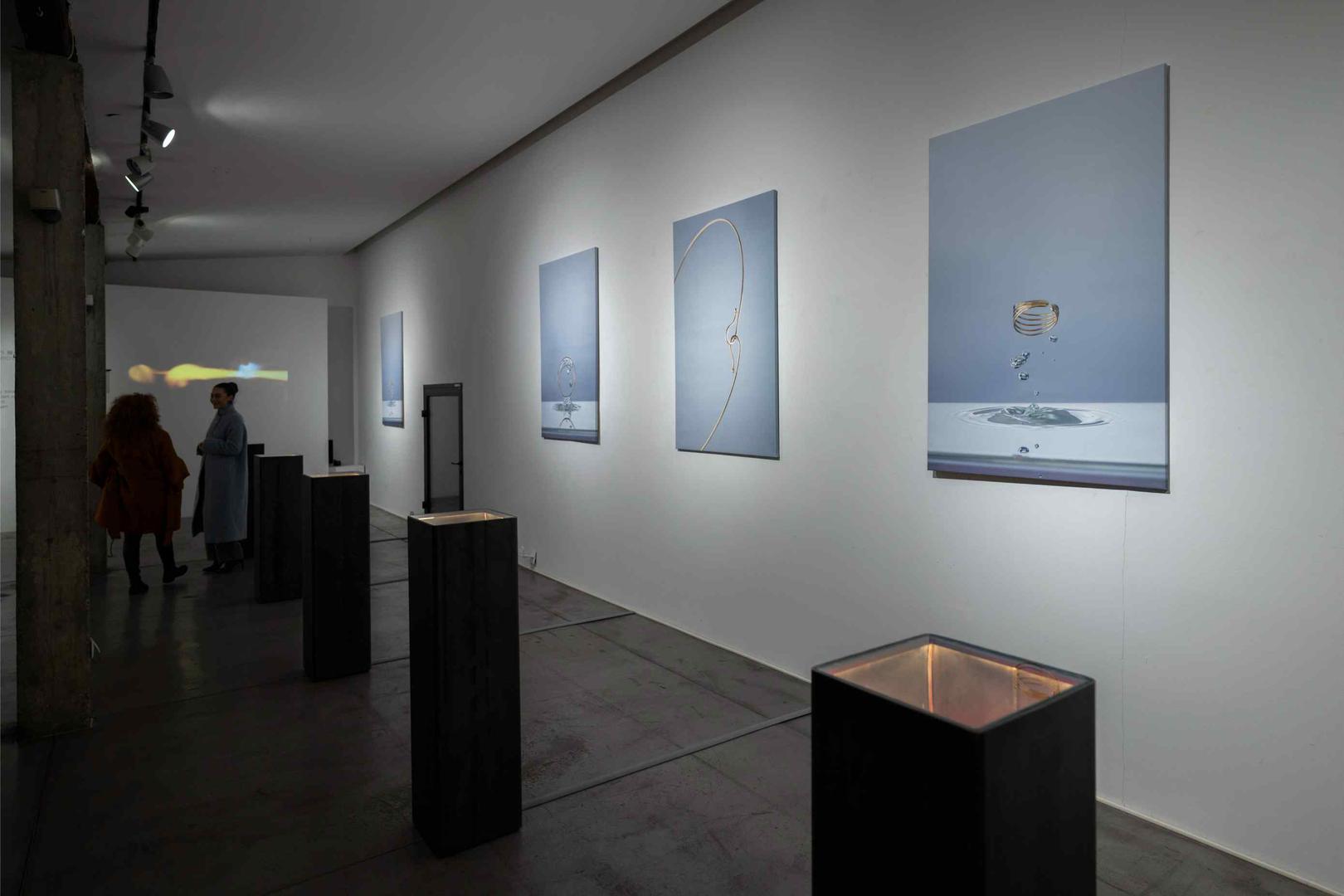 Monumentalni kadrovi i multimedijalna instalacija u izložbu unose performativni aspekt, dok minimalističke vitrine od sirovog čelika i vizualni identitet Jelenka Hercoga, temeljen na blago deformiranom krugu, naglašavaju plemenitost materijala i preciznost izvedbe