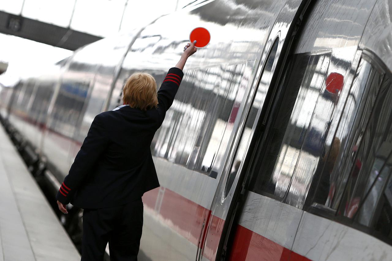 A Deutsche Bahn employee gestures before a train departure during a strike by GDL train drivers union at the main train station in Munich, Germany, May 20, 2015. German train drivers announced on May 18, 2015 their ninth strike in an ongoing dispute with 